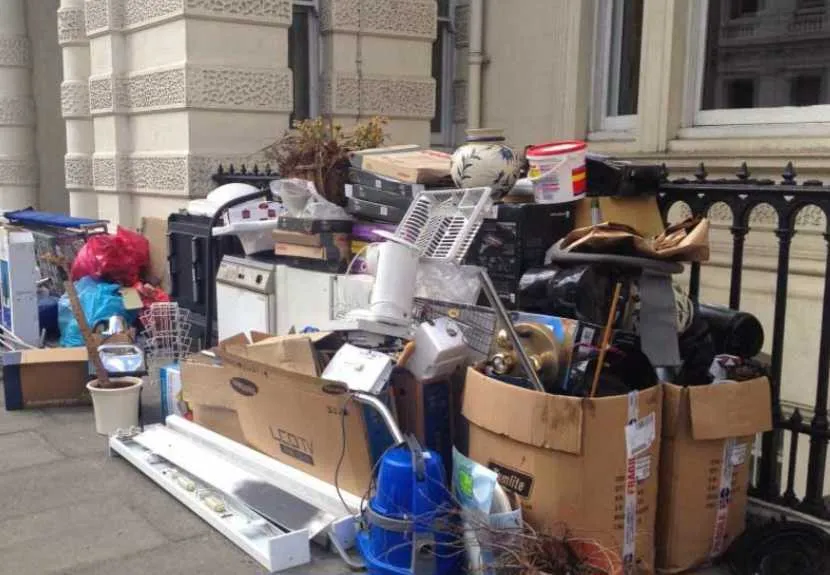 a pile of boxes and objects outside a building